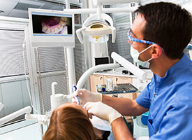 Dentist using intraoral camera on patient